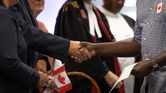 unidentifiable people shaking hands at citizenship ceremony